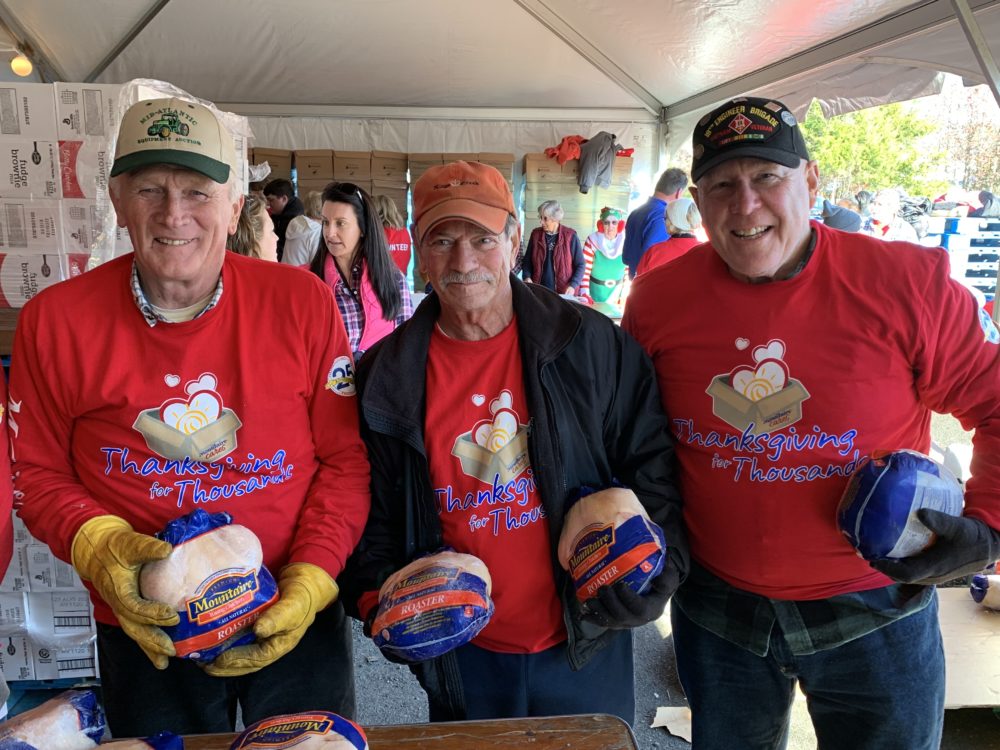 3 men holding chicken roasters