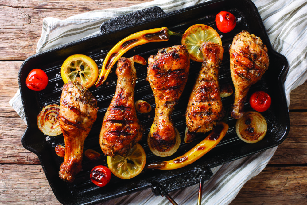 Home barbecue grilled chicken drumstick legs with vegetables in